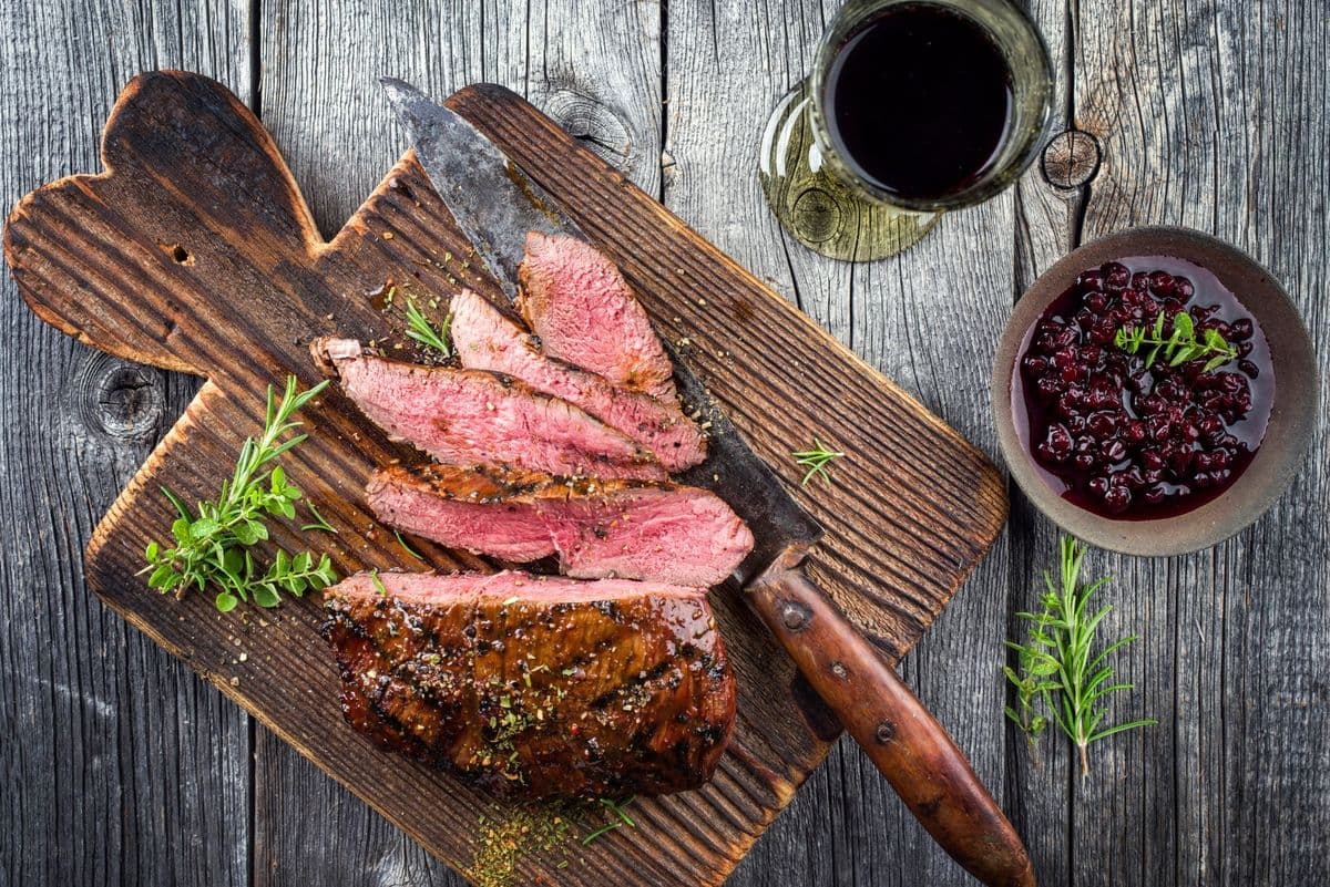 Barbecue Vanison Steak as top-view on old Cutting Board