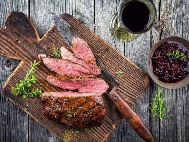 Barbecue Vanison Steak as top-view on old Cutting Board
