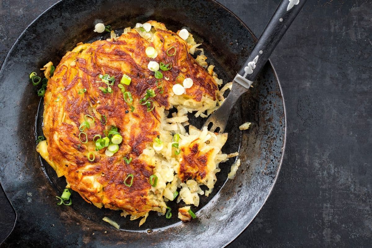 Traditional Swiss rosti as side dish with leek as top view in a