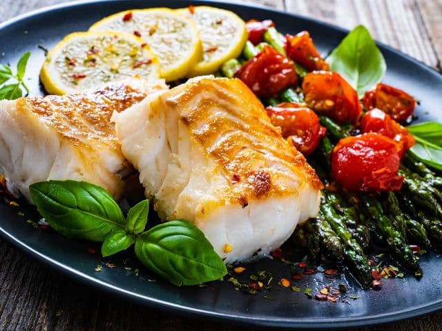 Gegrilltes Heilbutt-Filet mit Spargel, Tomaten und Zitronen